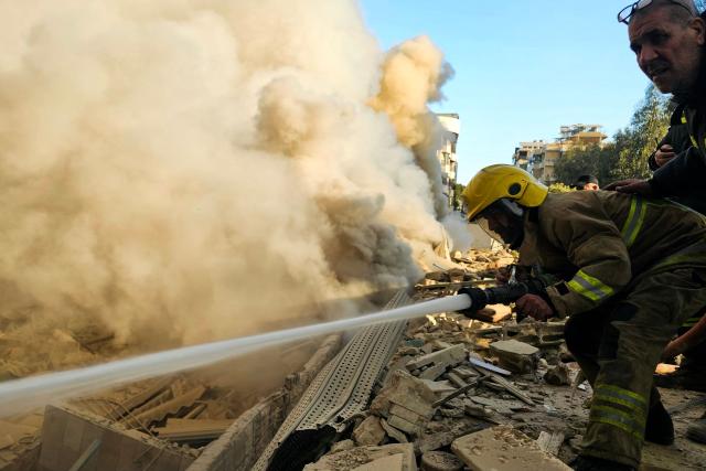 TOPSHOT - Firefighters extinguish fires at the site of an Israeli airstrike on the southern suburbs of Beirut on March 3, 2026. The Israeli military issued new evacuation orders for dozens of locations in Lebanon on March 3, including warning residents in two southern Beirut neighbourhoods to stay away from several buildings ahead of an imminent operation. (Photo by AFP)