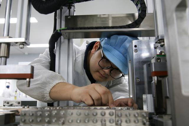 A man works on lithium batteries for export orders at Yunqi Lithium Energy's factory in the high-tech zone of Suichuan county, in China's eastern Jiangxi province, on March 2, 2026. (Photo by CN-STR / AFP) / China OUT
