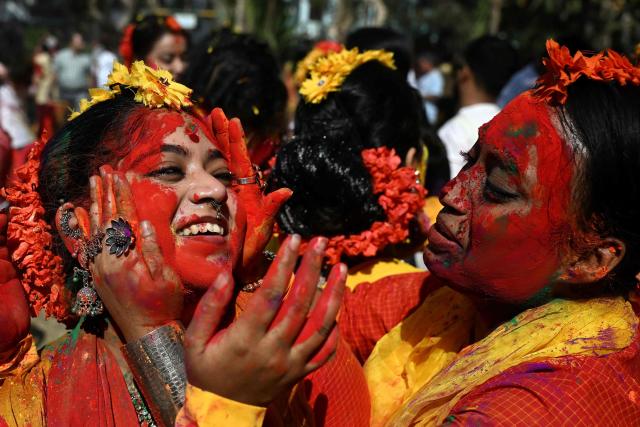 Women smear eachother with coloured powder to celebrate Holi, the Hindu spring festival of colours in Kolkata on March 3, 2026.  (Photo by Dibyangshu SARKAR / AFP)