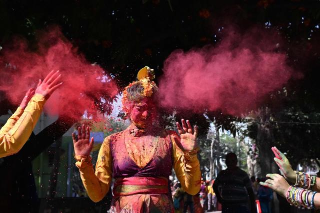 TOPSHOT - A woman is smeared with coloured powder as she celebrates Holi, the Hindu spring festival of colours in Kolkata on March 3, 2026.  (Photo by Dibyangshu SARKAR / AFP)