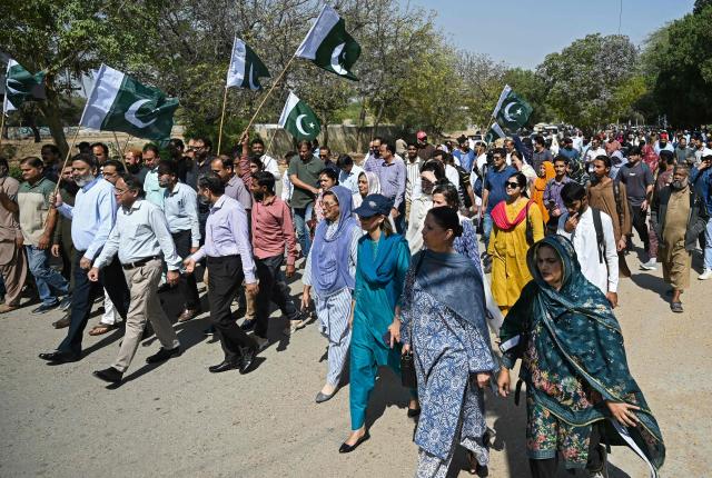 Karachi University teachers and students wave Pakistan's national flag during an anti-Afghan protest amid Pakistan-Afghanistan cross-border conflict in Karachi on March 3, 2026. AFP journalists in Kabul heard multiple explosions and gunfire on March 3, as Afghan and Pakistani troops keep up their border battles. (Photo by Rizwan TABASSUM / AFP)