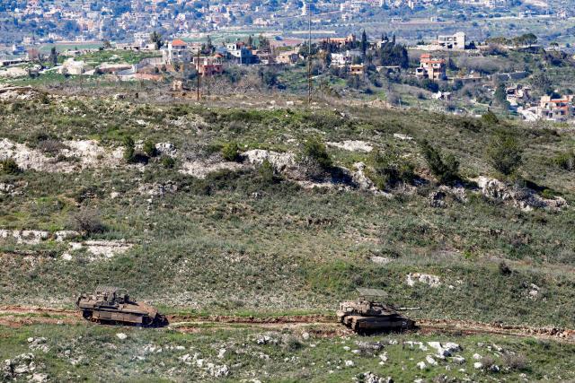 An Israeli army Merkava Mark IV main battle tank and infantry fighting vehicle (IFV) deploy at a position along the border between northern Israel and southern Lebanon on March 3, 2026. Israel on March 3 ordered the military to take control of more positions in Lebanon, where the army pulled back some of its forces after Hezbollah attacked Israeli bases in support of its backer, Iran. (Photo by Jalaa MAREY / AFP)