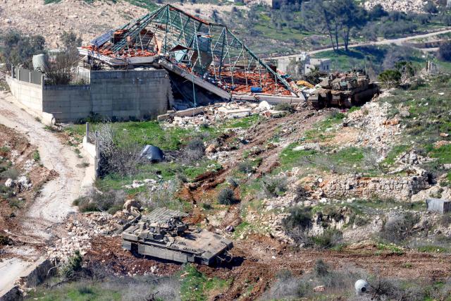 An Israeli army Merkava Mark IV main battle tank and infantry fighting vehicle (IFV) deploy at a position along the border between northern Israel and southern Lebanon on March 3, 2026. Israel on March 3 ordered the military to take control of more positions in Lebanon, where the army pulled back some of its forces after Hezbollah attacked Israeli bases in support of its backer, Iran. (Photo by Jalaa MAREY / AFP)