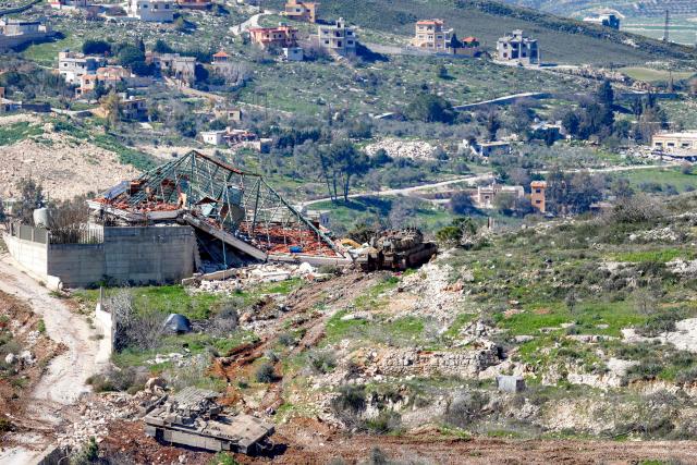 An Israeli army Merkava Mark IV main battle tank and infantry fighting vehicle (IFV) deploy at a position along the border between northern Israel and southern Lebanon on March 3, 2026. Israel on March 3 ordered the military to take control of more positions in Lebanon, where the army pulled back some of its forces after Hezbollah attacked Israeli bases in support of its backer, Iran. (Photo by Jalaa MAREY / AFP)