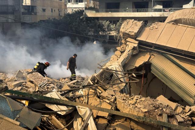 Firefighters inspect destruction at a site of an Israeli airstrike in the southern suburbs of Beirut on March 3, 2026. The war launched by the United States and Israel against Iran spread across the Middle East, threatening to plunge the global economy into chaos, with Lebanon and Gulf energy exporters dragged into the conflict. (Photo by AFP stringer / AFP)