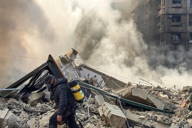 A firefighter inspects destruction at a site of an Israeli airstrike in the southern suburbs of Beirut on March 3, 2026. The war launched by the United States and Israel against Iran spread across the Middle East, threatening to plunge the global economy into chaos, with Lebanon and Gulf energy exporters dragged into the conflict. (Photo by AFP stringer / AFP)