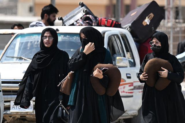 Pakistanis walk across the Taftan border as they return from Iran, in Balochistan province on March 3, 2026 amid ongoing US-Israel strikes on Iran. Pakistani nationals hauled suitcases across the border from neighbouring Iran, describing missiles being launched and travel chaos as they scrambled to leave the country after the US and Israel launched strikes over the weekend. (Photo by Banaras KHAN / AFP)