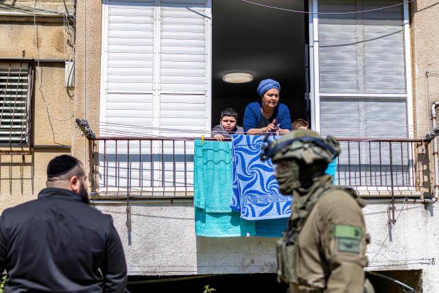 Security personnel conduct a search after a projectile hit the area of Petah Tikva in central Israel on March 3, 2026. The United States and Israel started striking Iran on February 28, killing Iran's supreme leader and top military leaders, and prompting authorities to retaliate with strikes on Israel and across the Gulf. (Photo by Ilia YEFIMOVICH / AFP)