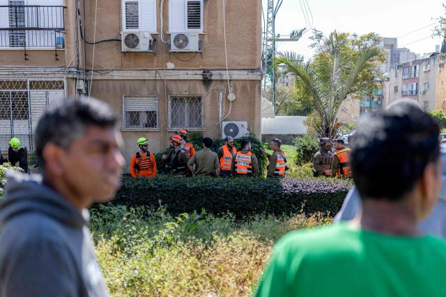Security personnel conduct a search after a projectile hit the area of Petah Tikva in central Israel on March 3, 2026. The United States and Israel started striking Iran on February 28, killing Iran's supreme leader and top military leaders, and prompting authorities to retaliate with strikes on Israel and across the Gulf. (Photo by Ilia YEFIMOVICH / AFP)
