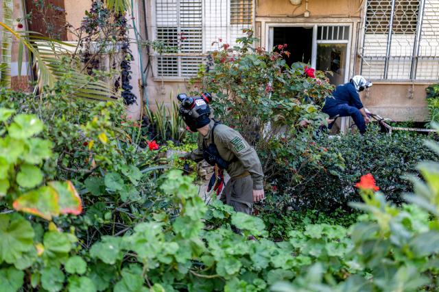 Security personnel conduct a search after a projectile hit the area of Petah Tikva in central Israel on March 3, 2026. The United States and Israel started striking Iran on February 28, killing Iran's supreme leader and top military leaders, and prompting authorities to retaliate with strikes on Israel and across the Gulf. (Photo by Ilia YEFIMOVICH / AFP)