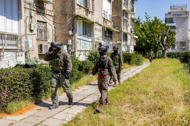 Security personnel conduct a search after a projectile hit the area of Petah Tikva in central Israel on March 3, 2026. The United States and Israel started striking Iran on February 28, killing Iran's supreme leader and top military leaders, and prompting authorities to retaliate with strikes on Israel and across the Gulf. (Photo by Ilia YEFIMOVICH / AFP)