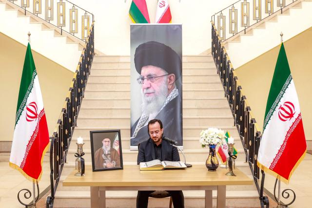 A man reads verses from the Koran, Islam's holy book, as mourners gather to pay their respects for Iran's slain supreme leader Ali Khamenei, who was was killed in a joint US-Israeli strike on Tehran on February 28, during a memorial service at the Iranian embassy headquarters in Oman's capital Muscat on March 3, 2026. The United States and Israel launched strikes against Iran on February 28, killing Iran's supreme leader and top military leaders, prompting authorities to retaliate with strikes on Israel and US bases across the Gulf. (Photo by Haitham AL-SHUKAIRI / AFP)