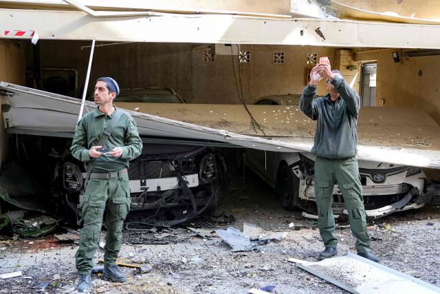 Security personnel conduct a search after a projectile hit the area of Petah Tikva in central Israel on March 3, 2026. The United States and Israel started striking Iran on February 28, killing Iran's supreme leader and top military leaders, and prompting authorities to retaliate with strikes on Israel and across the Gulf. (Photo by Jack GUEZ / AFP)