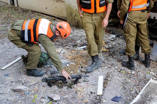 Security personnel conduct a search after a projectile hit the area of Petah Tikva in central Israel on March 3, 2026. The United States and Israel started striking Iran on February 28, killing Iran's supreme leader and top military leaders, and prompting authorities to retaliate with strikes on Israel and across the Gulf. (Photo by Jack GUEZ / AFP)