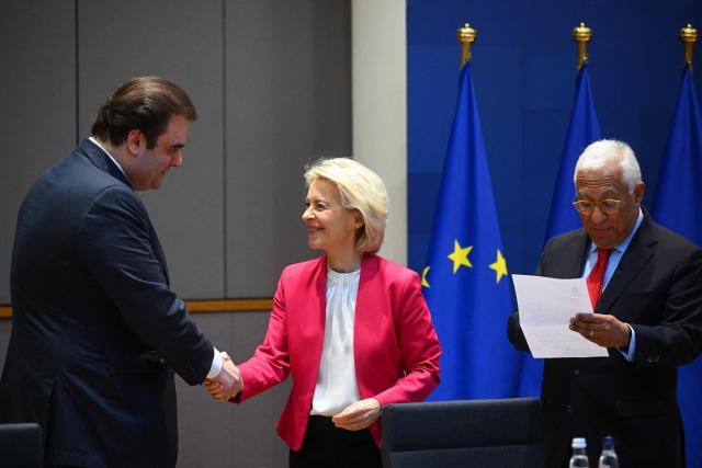 European Commission President Ursula von der Leyen (C) greets President of the Eurogroup Kyriakos Pierrakakis (L) next to European Council President Antonio Costa (R) prior to an inter-institutional meeting at the European Council headquarters in Brussels on March 3, 2026. kyri (Photo by Nicolas TUCAT / AFP)