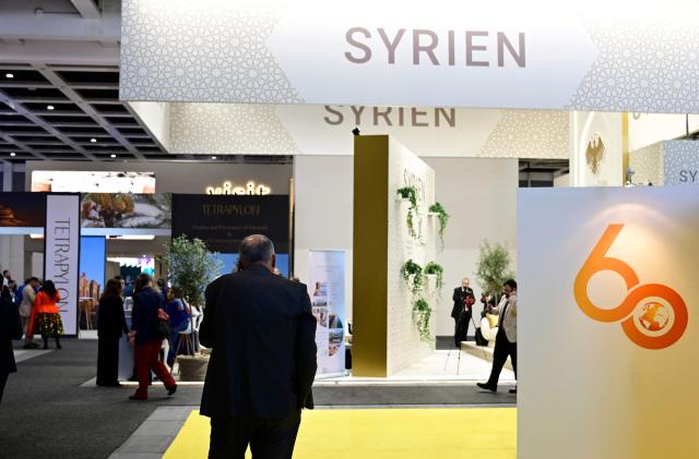 A man stands at the boot of Syria on the opening day of the ITB (Internationale Tourismus-Boerse) tourism fair in Berlin on March 3, 2026. Around 190 countries are represented at the platform for the global travel and tourism industry running from March 3 to 5, 2026. (Photo by Tobias SCHWARZ / AFP)