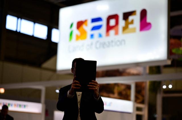 A fair goer stands in front of the booth of Israel, that stays closed "due to the current situation and circumstances in the Middle East", on the opening day of the ITB (Internationale Tourismus-Boerse) tourism fair in Berlin on March 3, 2026. Around 190 countries are represented at the platform for the global travel and tourism industry running from March 3 to 5, 2026. (Photo by Tobias SCHWARZ / AFP)
