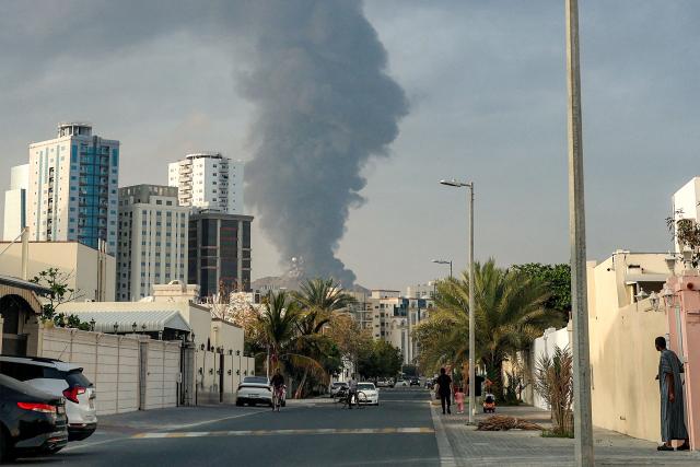 People watch from a street as a tall smoke plume billows following an explosion in the Fujairah industrial zone on March 3, 2026. Iran's strikes on Gulf neighbours since February 28, following the US-Israeli attack, forced the UAE to shut its airspace, blindsiding travellers who thought they were headed to one of the region's safest holiday destinations. (Photo by Fadel SENNA / AFP)