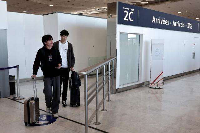 Passengers arrive from a flight coming from Dubai at Roissy-Charles de Gaulle Airport on the outskirts of Paris, on March 3, 2026. Thousands of flights have been delayed or cancelled in the biggest disruption to global air transport since the Covid pandemic as airlines suspend services to the Middle East following the US and Israeli attacks on Iran. (Photo by STEPHANE DE SAKUTIN / AFP)