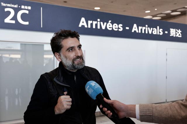 A passenger speaks to the press after disembarking from a flight coming from Dubai at Roissy-Charles de Gaulle Airport on the outskirts of Paris, on March 3, 2026. Thousands of flights have been delayed or cancelled in the biggest disruption to global air transport since the Covid pandemic as airlines suspend services to the Middle East following the US and Israeli attacks on Iran. (Photo by STEPHANE DE SAKUTIN / AFP)