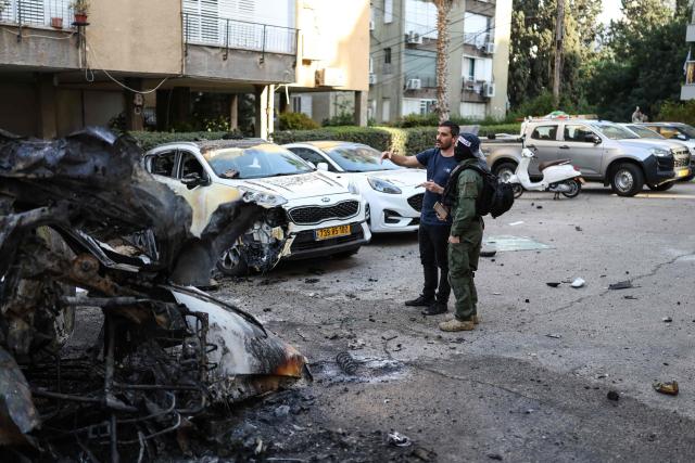 Israeli security forces stand next to the wreckage of cars as they inspect a site struck by a projectile in Ramat Gan near Tel Aviv on March 3, 2026. The Middle East has becomed gripped by a war triggered by US and Israel launched airstrikes against Iran on February 28, that killed the Islamic republic's supreme leader and other officials. (Photo by Ilia YEFIMOVICH / AFP)
