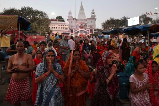 Hindu devotees pray before taking holy dip in the river Ganges during a total lunar eclipse, in Varanasi on March 3, 2026. (Photo by Niharika KULKARNI / AFP)