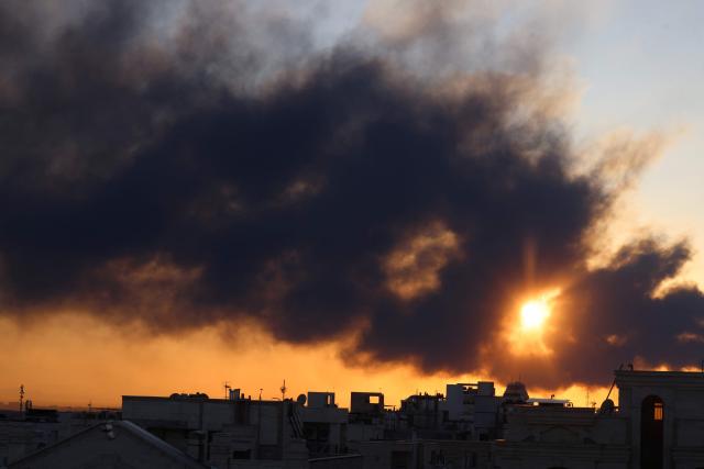 The sun is seen setting through a plume of black smoke following a strike on the Iranian capital Tehran, on March 3, 2026. Iran stepped up its attacks on economic targets and US missions across the Middle East on Tuesday as the US president warned it was "too late" for the Islamic republic to seek talks to escape the war.  The United States and Israel launched strikes against Iran on February 28, with the killing of Iran's supreme leader and the Islamic republic retaliated with barrages of missiles at Gulf states and Israel. (Photo by ATTA KENARE / AFP)