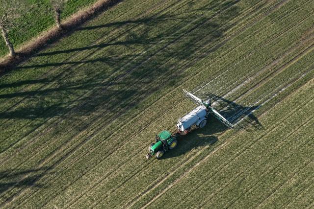This aerial view shows a farmer spreading liquid manure on a field, in Hede-bazouhes, western France, on March 3, 2026. (Photo by Damien MEYER / AFP)