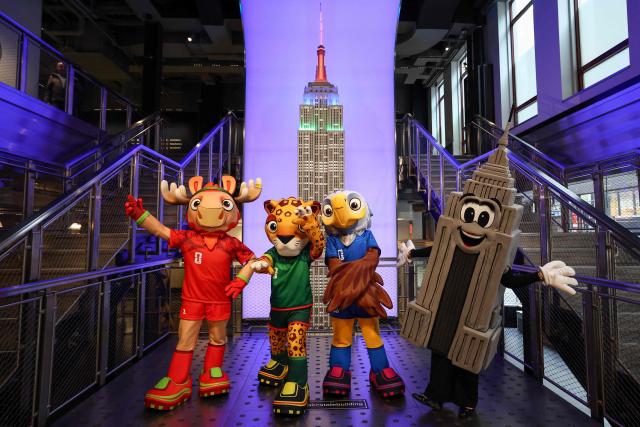 FIFA World Cup mascots Maple, Zayu and Clutch pose with Emma Pire inside the Empire State Building to celebrate 100 days to the World Cup in New York on March 3, 2026. The 100-day countdown to the biggest World Cup in history gets under way on Tuesday against a chaotic backdrop of global unrest, from US-Israeli strikes on Iran to surging violence in Mexico and anxiety over Donald Trump's domestic agenda. A record 48 teams and millions of fans are set to descend on the United States, Canada and Mexico for the first ever World Cup shared by three nations. (Photo by CHARLY TRIBALLEAU / AFP)