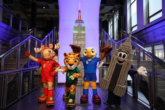 FIFA World Cup mascots Maple, Zayu and Clutch pose with Emma Pire inside the Empire State Building to celebrate 100 days to the World Cup in New York on March 3, 2026. The 100-day countdown to the biggest World Cup in history gets under way on Tuesday against a chaotic backdrop of global unrest, from US-Israeli strikes on Iran to surging violence in Mexico and anxiety over Donald Trump's domestic agenda. A record 48 teams and millions of fans are set to descend on the United States, Canada and Mexico for the first ever World Cup shared by three nations. (Photo by CHARLY TRIBALLEAU / AFP)