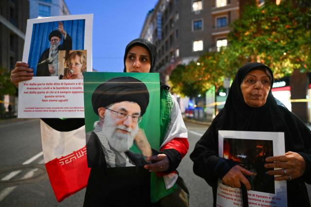 Women hold pictures of assassinated Iranian supreme leader Ayatollah Ali Khamenei and an Iranian flag during a protest against the US and Israel attack of Iran near the US Embassy in Rome, on March 3, 2026. The United States and Israel launched strikes against Iran on February 28, killing Iran's supreme leader and top military leaders, prompting authorities to retaliate with strikes on Israel and across the Gulf. (Photo by Alberto PIZZOLI / AFP)