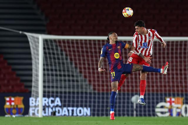 Barcelona's Brazilian forward #11 Raphinha (L) and Atletico Madrid's Spanish defender #18 Marc Pubill vie for a header during the Copa del Rey (King's Cup) semi final second leg football match between FC Barcelona and Club Atletico de Madrid at Camp Nou Stadium in Barcelona on March 3, 2026. (Photo by Josep LAGO / AFP)