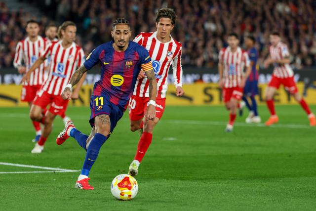 Barcelona's Brazilian forward #11 Raphinha (C) runs for the ball with Atletico Madrid's Argentine forward #20 Giuliano Simeone during the Copa del Rey (King's Cup) semi final second leg football match between FC Barcelona and Club Atletico de Madrid at Camp Nou Stadium in Barcelona on March 3, 2026. (Photo by Lluis GENE / AFP)