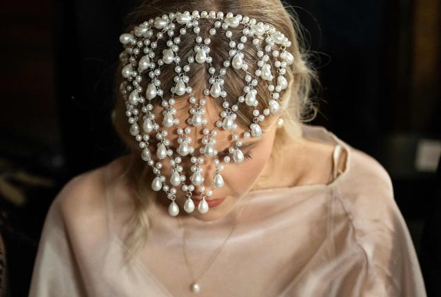 A guest wears a pearl headpiece as she arrive for a Women's Ready to Wear Fall/Winter 2026-2027 collection fashion show as part of the Paris Women Fashion Week, at the Palais Garnier, in Paris, on March 3, 2026. (Photo by Blanca CRUZ / AFP)
