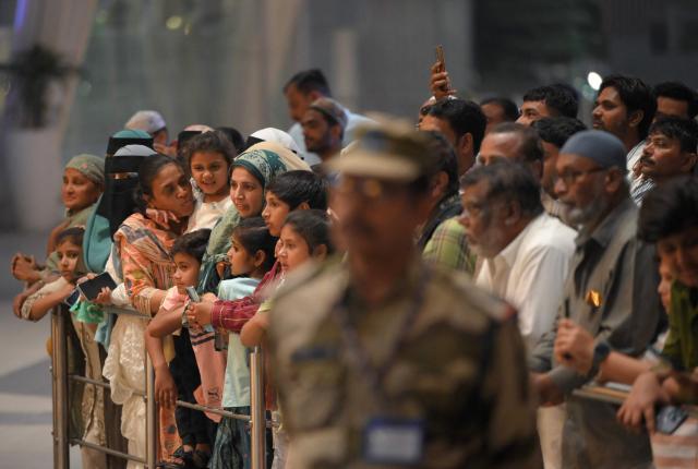 Relatives wait for the arrival of Indian Muslim passengers at the airport of Ahmedabad on late March 3, 2026, after they were stranded in Jeddah (Saudi Arabia) as they visited for special prayer in ongoing Ramadan month, following the eruption of a regional conflict sparked by Israel-US strikes on Iran. Governments and airlines scrambled on March 3, 2026 to repatriate tens of thousands of travellers stranded in the Middle East. (Photo by Shammi MEHRA / AFP)