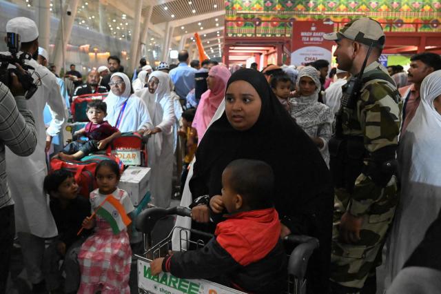 Indian Muslim passengers arrive at the airport of Ahmedabad on late March 3, 2026, after they were stranded in Jeddah (Saudi Arabia) as they visited for special prayer in ongoing Ramadan month, following the eruption of a regional conflict sparked by Israel-US strikes on Iran. Governments and airlines scrambled on March 3, 2026 to repatriate tens of thousands of travellers stranded in the Middle East. (Photo by Shammi MEHRA / AFP)