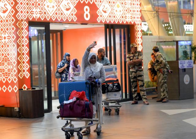 Indian Muslim passengers arrive at the airport of Ahmedabad on late March 3, 2026, after they were stranded in Jeddah (Saudi Arabia) as they visited for special prayer in ongoing Ramadan month, following the eruption of a regional conflict sparked by Israel-US strikes on Iran. Governments and airlines scrambled on March 3, 2026 to repatriate tens of thousands of travellers stranded in the Middle East. (Photo by Shammi MEHRA / AFP)