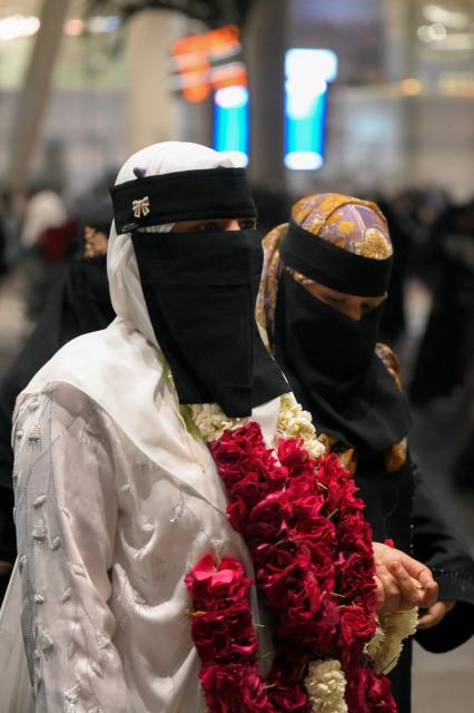 Indian Muslim passengers arrive at the airport of Ahmedabad on late March 3, 2026, after they were stranded in Jeddah (Saudi Arabia) as they visited for special prayer in ongoing Ramadan month, following the eruption of a regional conflict sparked by Israel-US strikes on Iran. Governments and airlines scrambled on March 3, 2026 to repatriate tens of thousands of travellers stranded in the Middle East. (Photo by Shammi MEHRA / AFP)