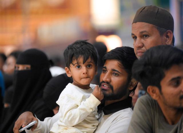 Relatives wait for the arrival of Indian Muslim passengers at the airport of Ahmedabad on late March 3, 2026, after they were stranded in Jeddah (Saudi Arabia) as they visited for special prayer in ongoing Ramadan month, following the eruption of a regional conflict sparked by Israel-US strikes on Iran. Governments and airlines scrambled on March 3, 2026 to repatriate tens of thousands of travellers stranded in the Middle East. (Photo by Shammi MEHRA / AFP)