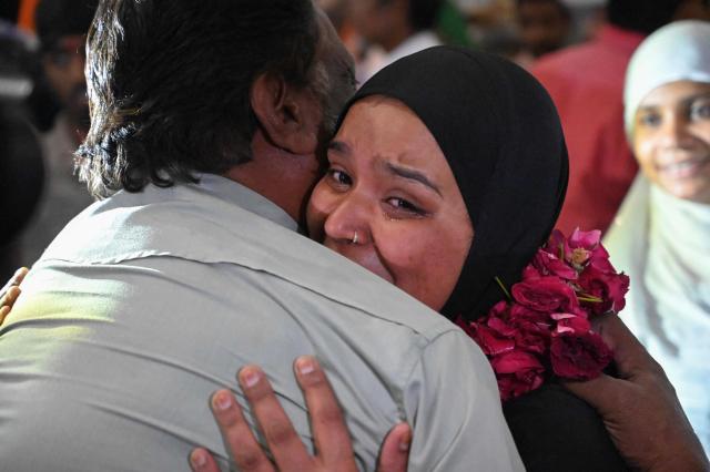 An Indian Muslim passenger reacts as she is welcomed upon their arrival at the airport of Ahmedabad on late March 3, 2026, after she was stranded in Jeddah (Saudi Arabia) as she visited for special prayer in ongoing Ramadan month, following the eruption of a regional conflict sparked by Israel-US strikes on Iran. Governments and airlines scrambled on March 3, 2026 to repatriate tens of thousands of travellers stranded in the Middle East. (Photo by Shammi MEHRA / AFP)