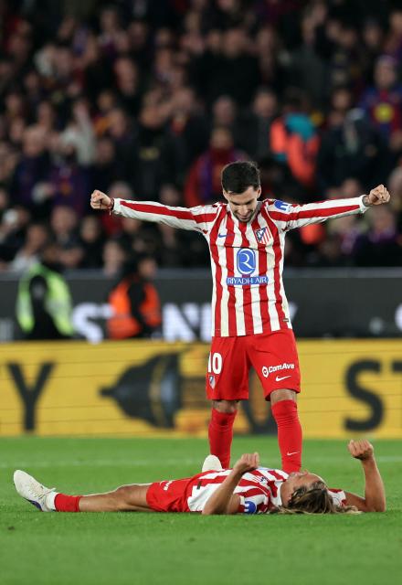 Atletico Madrid's Spanish forward #10 Alex Baena and Atletico Madrid's Spanish midfielder #14 Marcos Llorente (BOTTOM) celebrate their victory at the end of the Copa del Rey (King's Cup) semi final second leg football match between FC Barcelona and Club Atletico de Madrid at Camp Nou Stadium in Barcelona on March 3, 2026. (Photo by Josep LAGO / AFP)