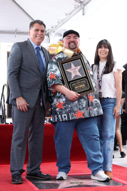 Sheriff of LA Robert Luna (L) and his wife Celines Luna (R) pose with US comedian and actor Gabriel "Fluffy" Iglesias during Iglesias' Walk of Fame Star ceremony in the Hollywood neighborhood of Los Angeles, California on March 3, 2026. (Photo by VALERIE MACON / AFP)