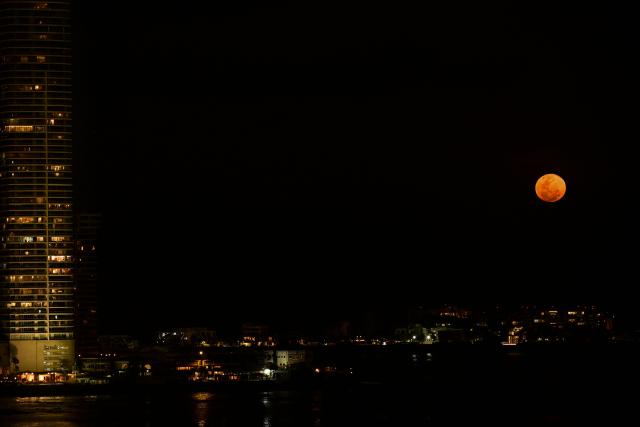 EDITORS NOTE: Graphic content / The moon rises in its waxing gibbous phase over the artificial islands of Ocean Reef Islands in Panama City on March 3, 2026. (Photo by Martin BERNETTI / AFP)