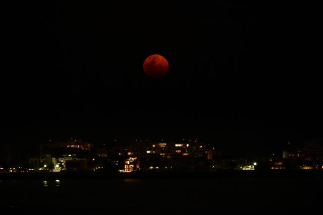 EDITORS NOTE: Graphic content / The moon rises in its waxing gibbous phase over the artificial islands of Ocean Reef Islands in Panama City on March 3, 2026. (Photo by Martin BERNETTI / AFP)