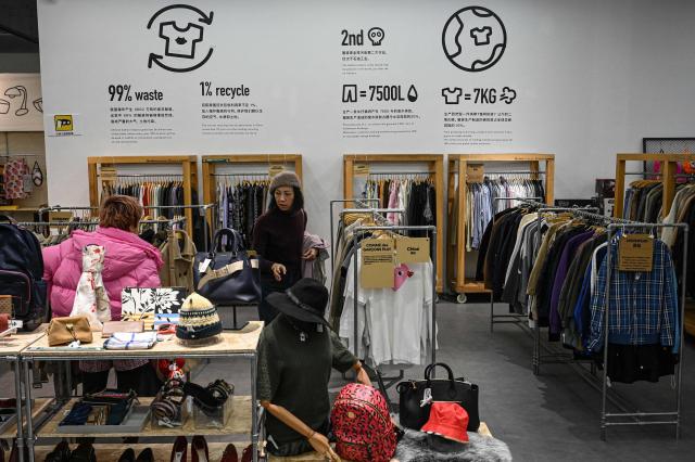 The photo taken on February 10, 2026 shows people browsing through products at a second-hand store in Shanghai. Boosting domestic consumption will be among key goals set forth by China's leaders at the annual Two Sessions political conclave this week, but they face an uphill battle. (Photo by Jade GAO / AFP) / To go with AFP story:  China-economy-politics-consumer-travel-retail, FOCUS by Jing Xuan TENG and Peter CATTERALL