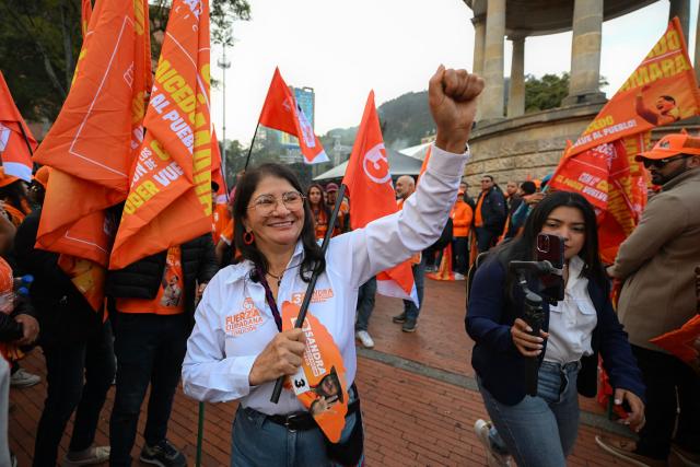 Sandra Ramirez, candidate for the Senate of Colombia for the Fuerza Ciudadana party, and widow of Revolutionary Armed Forces of Colombia (FARC) top commander Manuel Marulanda, aka Tiro Fijo, raises her clenched fist during her campaigns closing event in Bogota on March 1, 2026. Sandra Ramirez dances, waves flags and gives speeches in squares. For the first time, the senator and former guerrilla fighter must win votes for Colombia's legislative elections, the FARC party's last political card to avoid disappearing. (Photo by Luis ACOSTA / AFP)