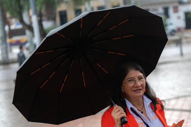 Sandra Ramirez, candidate for the Senate of Colombia for the Fuerza Ciudadana party, and widow of Revolutionary Armed Forces of Colombia (FARC) top commander Manuel Marulanda, aka Tiro Fijo, holds an umbrella as she speaks during an interview with AFP in Bogota on March 1, 2026. Sandra Ramirez dances, waves flags and gives speeches in squares. For the first time, the senator and former guerrilla fighter must win votes for Colombia's legislative elections, the FARC party's last political card to avoid disappearing. (Photo by Luis ACOSTA / AFP)
