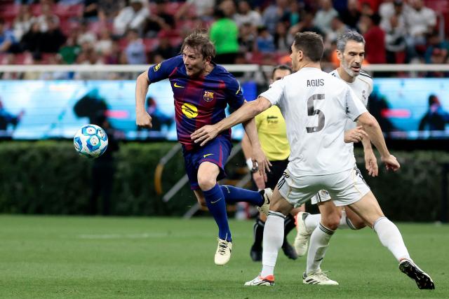 Barcelona's Spanish midfielder Gaizka Mendieta (L) controls the ball past Real Madrid's Spanish defender Agus (R) during the exhibition friendly football match between Spain's Real Madrid Legends and Barcelona Legends at the Akron Stadium in Guadalajara, Mexico, on March 3, 2026. (Photo by Ulises Ruiz / AFP)