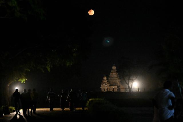 A full moon also known as the "Blood Moon", rises during a total lunar eclipse at the Shore temple in Mahabalipuram on March 3, 2026. (Photo by R. Satish BABU / AFP)