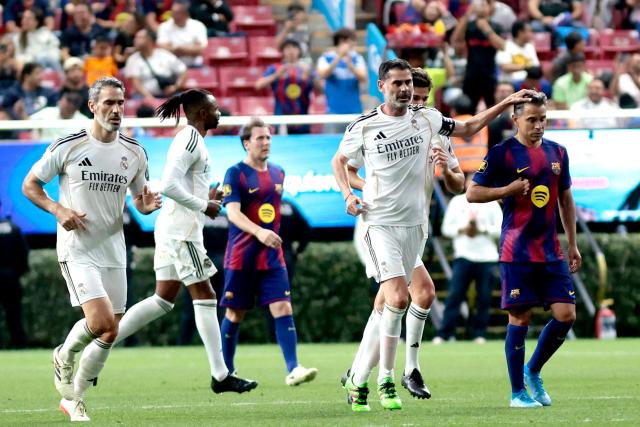 Real Madrid's Spanish defender Fernando Hierro (C) celebrates with Barcelona's Argentine forward Javier Saviola (R) after scoring a goal during the exhibition friendly football match between Spain's Real Madrid Legends and Barcelona Legends at the Akron Stadium in Guadalajara, Mexico, on March 3, 2026. (Photo by Ulises Ruiz / AFP)
